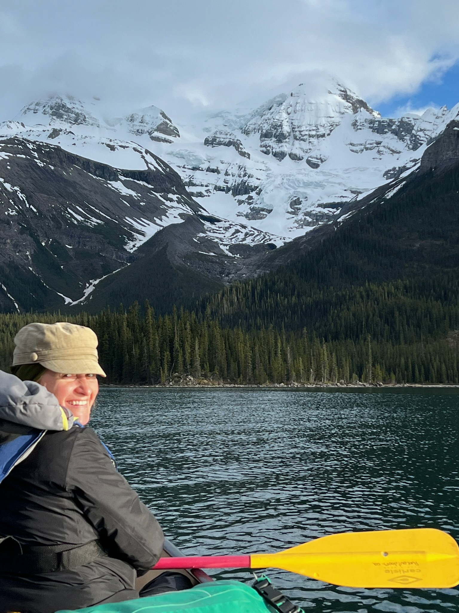 Woman kayaking on mountain lake with glacier peaks, Jasper National Park